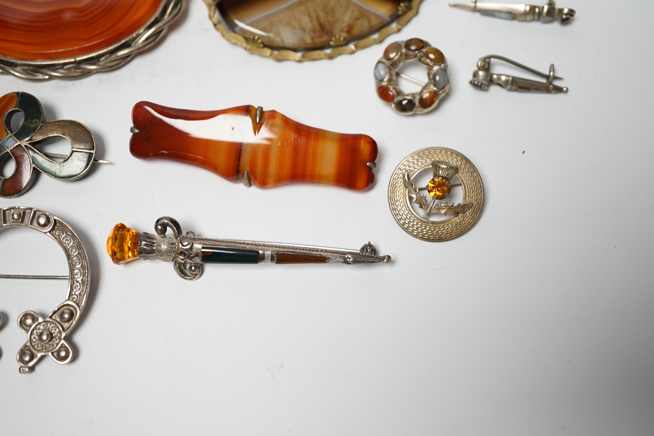 A small collection of mainly silver, sterling and white metal jewellery including Celtic brooches, Iona ship brooch, a Scottish hardstone set bugle brooch and other moss agate set and banded agate set items, largest broo
